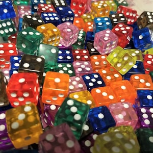 May include: A large pile of colorful transparent dice with white dots. The dice are made of plastic and are in various colors, including red, blue, green, yellow, orange, and purple.