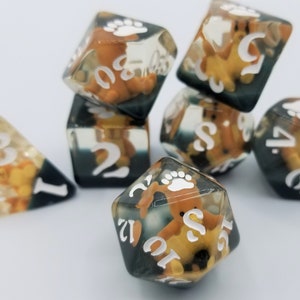 May include: Set of six clear dice with black and white numbers and a brown bear paw print. The dice are filled with a clear resin and contain a small brown bear figurine inside.