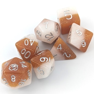 May include: Set of six polyhedral dice with a white and brown speckled finish. The dice are numbered 1 through 6 and have silver metallic numbers.