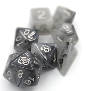 May include: A set of six black and silver dice with various numbers on each face. The dice are made of a translucent material, and the numbers are visible through the material.