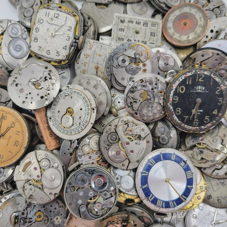 May include: A collection of vintage watch parts, including watch faces, gears, and internal mechanisms. The components are in various states of wear, with visible numbers, hands, and brand names. The color palette includes silver, gold, and black.