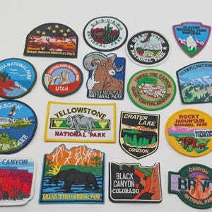 Könnte beinhalten: Eine Sammlung von siebzehn bestickten Aufnähern verschiedener US-Nationalparks, darunter Grand Canyon, Saguaro, Grand Teton, Glacier, Acadia, Utah, Rocky Mountain, Yellowstone, Crater Lake, Bryce Canyon und Black Canyon.
