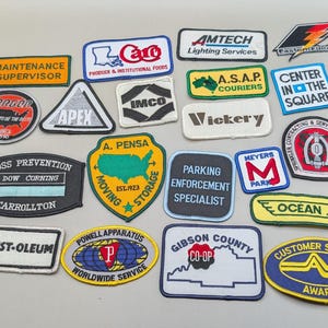 Puede incluir: Una colección de veintiún parches de tela bordados con diversos logotipos de empresas, títulos de servicios y formas geográficas. Los parches incluyen textos como Maintenance Supervisor, A.S.A.P. Couriers, Rust-Oleum y Gibson County Co-Op.