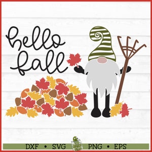 May include: A gnome with a green and white striped hat holds a rake and a red maple leaf. The gnome is standing in front of a pile of colorful fall leaves. The text "hello fall" is written in black cursive above the gnome.