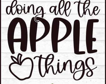 May include: Black and white graphic design with the words "doing all the APPLE things" in a whimsical font. An apple illustration is included. The design is on a white wooden background. The bottom of the image includes file type options.