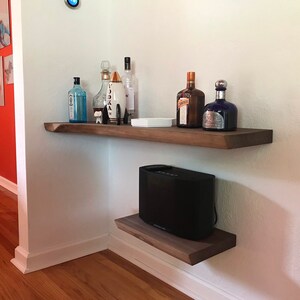 These HEAVY DUTY live edge floating shelves (floating bracket included) are handmade from SOLID 2" thick walnut. Use these floating shelves for storage, kitchen shelves or as a bookshelf. The possibilities are endless.