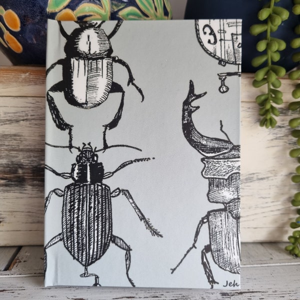 Hurdy-gurdy beetle design hard backed note book. Ruled feint. 64 paqes