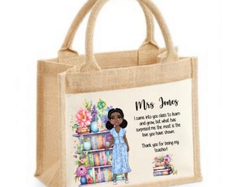 Puede incluir: Una bolsa de yute beige con un diseño blanco que presenta una ilustración de dibujos animados de una mujer negra de pie frente a una estantería. El texto en la bolsa dice "Sra. Jones Entré en su clase para aprender y crecer, pero lo que más me ha sorprendido es el amor que ha mostrado. ¡Gracias por ser mi maestra!"