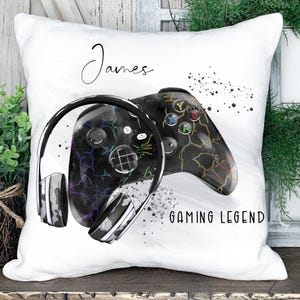 May include: White pillow with a black and white illustration of a gaming controller and headphones. The text "James" and "Gaming Legend" is printed on the pillow.