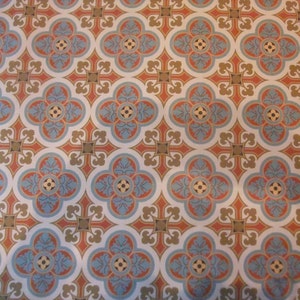 Peut inclure: Un motif géométrique répétitif de formes bleues, rouges et dorées sur un fond blanc. Le motif est composé de formes de trèfles à quatre feuilles avec un petit cercle au centre de chaque feuille. Les formes de trèfles sont entourées d'une forme de croix avec un petit cercle au centre de chaque bras.
