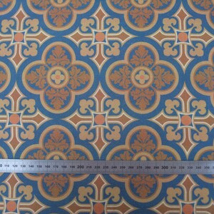 May include: A repeating pattern of blue, brown, and orange geometric shapes. The pattern features a four-leaf clover design with a central circle and a cross shape.