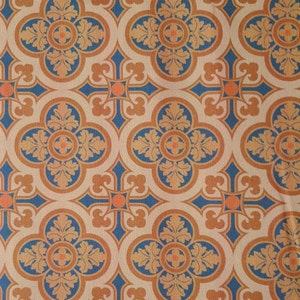 Könnte beinhalten: Ein sich wiederholendes Muster aus blauen, orangen und braunen geometrischen Formen auf weißem Hintergrund. Das Muster erinnert an ein traditionelles Fliesendesign.