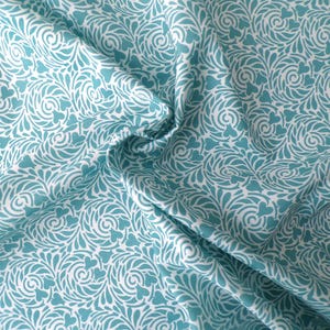 May include: White fabric with a teal blue swirling pattern of leaves and hearts.