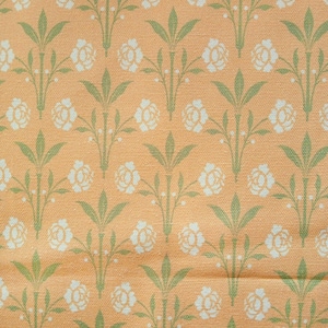 May include: A peach-coloured fabric with a repeating pattern of white flowers and green leaves.