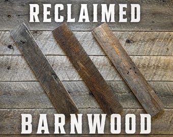 May include: Three rectangular planks of weathered reclaimed barnwood arranged diagonally against a matching wood background. The text RECLAIMED BARNWOOD is printed in large white capital letters across the top and bottom of the image.
