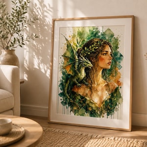 Puede incluir: Una impresión enmarcada de estilo acuarela que muestra a una persona con cabello oscuro adornado con una corona de hojas, acompañada por un pequeño dragón verde en el hombro. La obra usa tonos verdes, amarillos y marrones con salpicaduras.