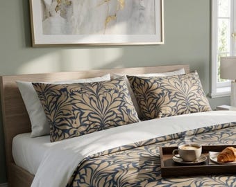 Könnte beinhalten: Ein Bett mit einer beige- und marineblauen Bettwäsche und Kissenbezügen mit floralem Muster. Ein Holztablett enthält eine Tasse Kaffee und ein Croissant. Ein gerahmtes abstraktes Kunstwerk hängt über dem Bett.