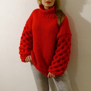 May include: A red knitted sweater with a turtleneck and bubble sleeves.