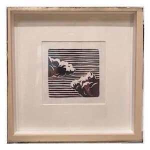 May include: A square framed print featuring a black and white linocut style illustration of two fluffy clouds set against a background of horizontal lines. The artwork is centered within a white mat and enclosed in a light-colored wooden frame.