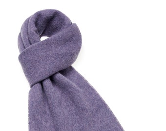 May include: A soft, purple scarf with long fringe tassels. The scarf is made of a fuzzy material and is folded in half.