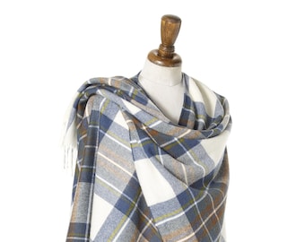 May include: A white, blue, and brown plaid shawl with fringe on a wooden mannequin.