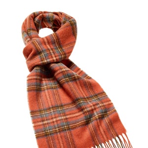 May include: A red and orange plaid scarf with fringe. The scarf is made of a soft, fuzzy material.