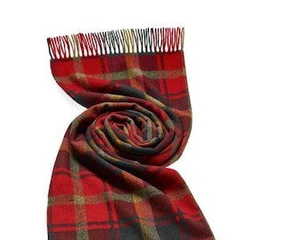 May include: A red, green and black plaid scarf with fringed edges. The scarf is folded and rolled into a circle.