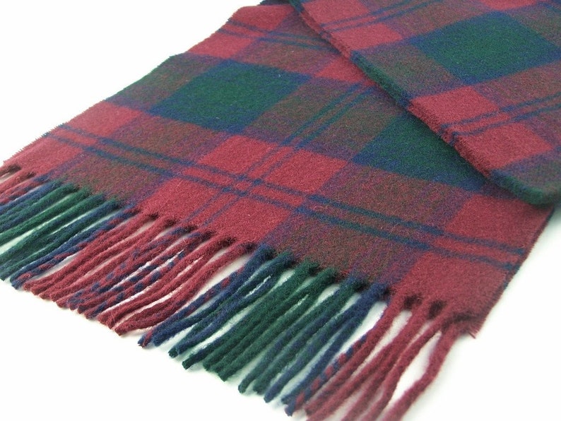 May include: A red, green and blue plaid scarf with fringe on the ends.