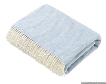 May include: A light blue throw blanket with a white herringbone pattern and white fringe.