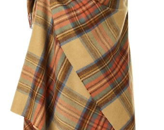 May include: A tan, brown, orange, and blue plaid shawl with fringe on the edges. The shawl is draped over a wooden mannequin.