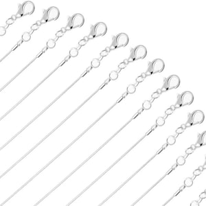 May include: A set of 12 silver chain necklaces with lobster claw clasps. The chains are all the same length and are arranged in a fan shape.