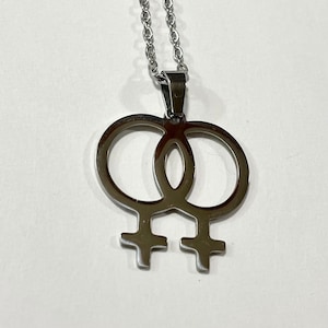 May include: A silver necklace with a double female symbol pendant.