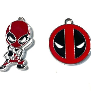 May include: Two metal charms featuring the superhero Deadpool. One charm is a red and black cartoon of Deadpool in a fighting pose. The other charm is a red and black circle with Deadpool's mask design.