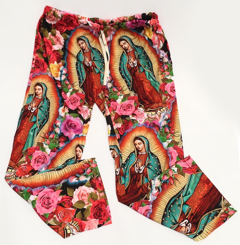 May include: Colorful pants with a floral pattern featuring images of the Virgin Mary. The pants are made of a soft, comfortable fabric and have a drawstring waist.