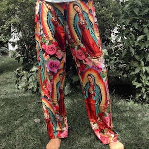 May include: Red, blue, and green pants with a repeating pattern of a religious figure in a gold frame and pink roses.