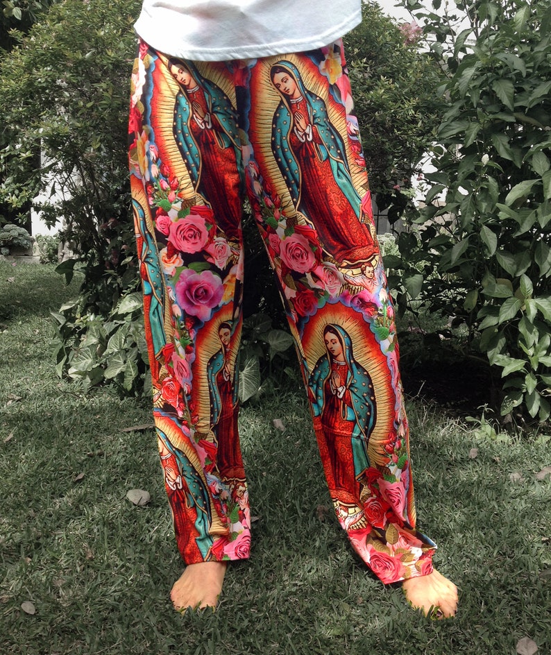 May include: Red, blue, and green pants with a repeating pattern of a religious figure in a gold frame and pink roses.