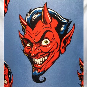 Pode incluir: Um padr&atilde;o repetido de um rosto de diabo vermelho com chifres, um cavanhaque e um sorriso largo em um fundo azul claro. O cabelo do diabo &eacute; preto com reflexos azuis e seus olhos s&atilde;o amarelos.