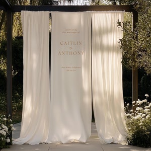 Könnte beinhalten: Ein weißer Stoffhintergrund mit dem Text "celebrating the marriage of CAITLIN to ANTHONY - Paso Robles, California 09.10.24" in Gold gedruckt.
