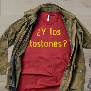 May include: Red t-shirt with the text "&iquest;Y los tostones?" in yellow.