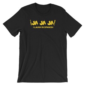 Może przedstawiać: Czarny T-shirt z ż&oacute;łtym tekstem, kt&oacute;ry brzmi "&iexcl;JA JA JA! I LAUGH IN SPANISH"