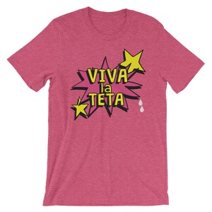 May include: Pink t-shirt with a yellow star and a pink speech bubble that says "Viva la Teta" in black text.