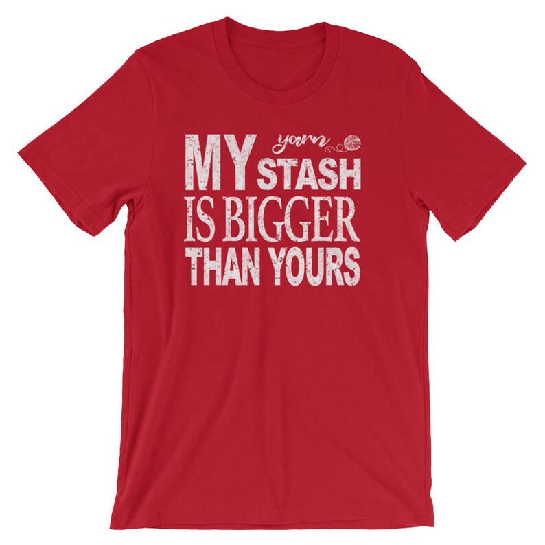 May include: Red short-sleeved t-shirt with white text that reads "My yarn stash is bigger than yours".