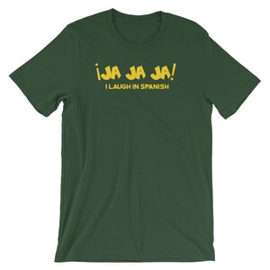 Może przedstawiać: Zielony T-shirt z napisem "&iexcl;JA JA JA! I LAUGH IN SPANISH" w kolorze ż&oacute;łtym.