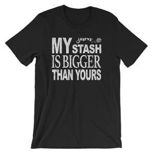 May include: Black t-shirt with white text that reads "My yarn stash is bigger than yours".