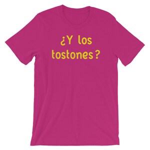 May include: A pink t-shirt with the text "&iquest;Y los tostones?" in yellow.
