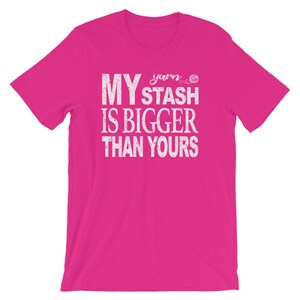 May include: Pink t-shirt with white text that reads "My yarn stash is bigger than yours".
