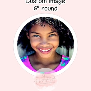 May include: A 6 inch round custom image sticker featuring a smiling young girl with curly hair wearing a pink and green patterned shirt. The sticker has a white border and a small logo in the bottom right corner that says "InBee Design Studio".