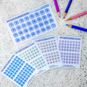 Può includere: Quattro fogli di adesivi con i numeri da 1 a 31 in cerchi di acquerello blu e rosa. Gli adesivi sono per l'uso in planner e diari. Il testo "My Fairy Planner Store" è stampato su ogni foglio.
