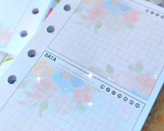 May include: White, floral-decorated planner pages with grid lines and the word "DATA" printed at the top. The pages have multiple holes for binding and feature pastel-colored flower designs.