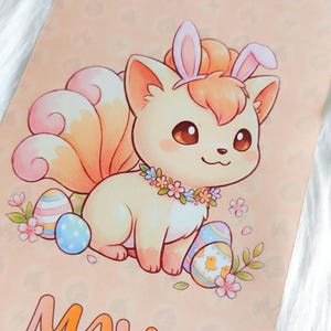 May include: A whimsical illustration of a fox-like creature with bunny ears, a floral necklace, and a fluffy tail, surrounded by Easter eggs and flowers. The word "MAY" is written in orange letters on a peach background.